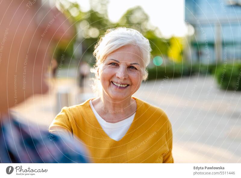 Portrait of happy senior couple standing in city street on a sunny day people caucasian healthy city life gray hair enjoy casual portrait outside real people