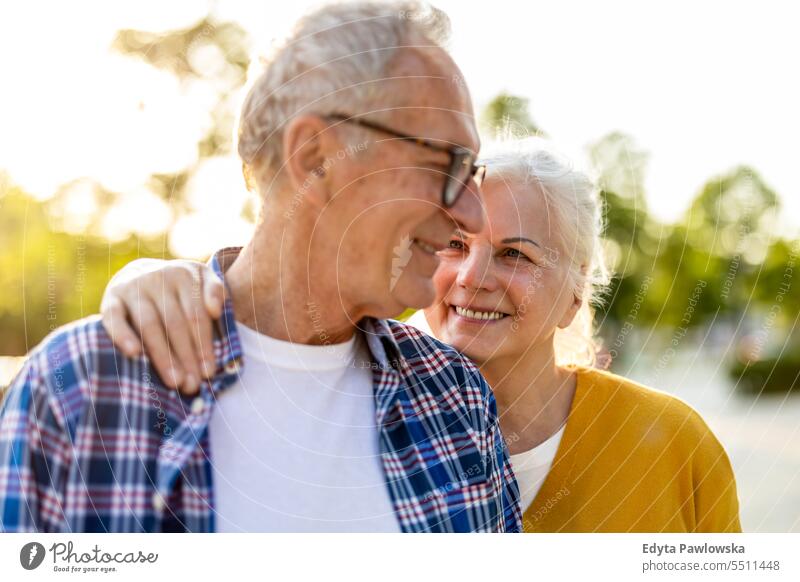 Portrait of a happy senior couple embracing outdoors people caucasian standing healthy city life gray hair enjoy street casual day portrait outside real people