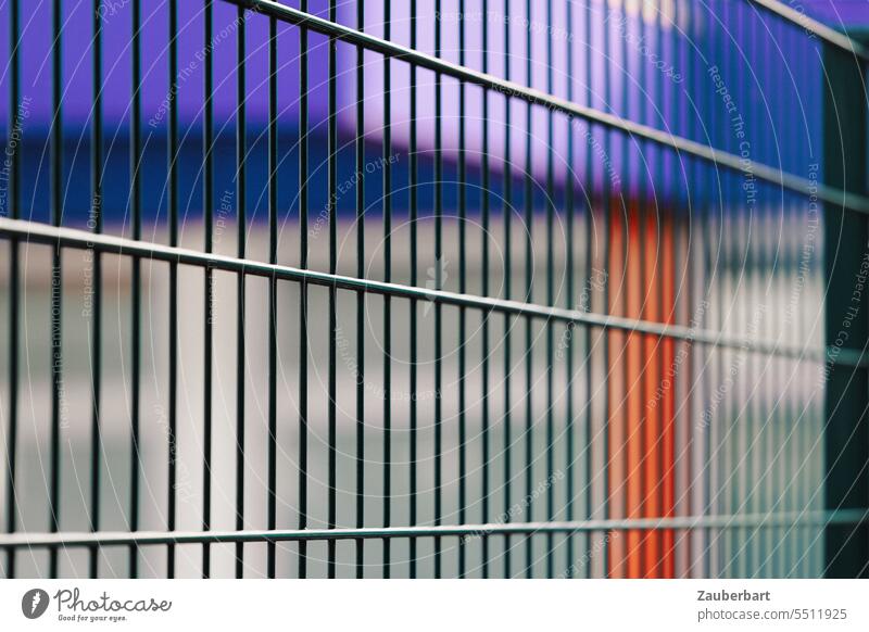 Fence in perspective, behind it blurred structures in blue and red Metal Perspective Escape Town Blue Red Captured captured inhospitably illusive Barrier Border