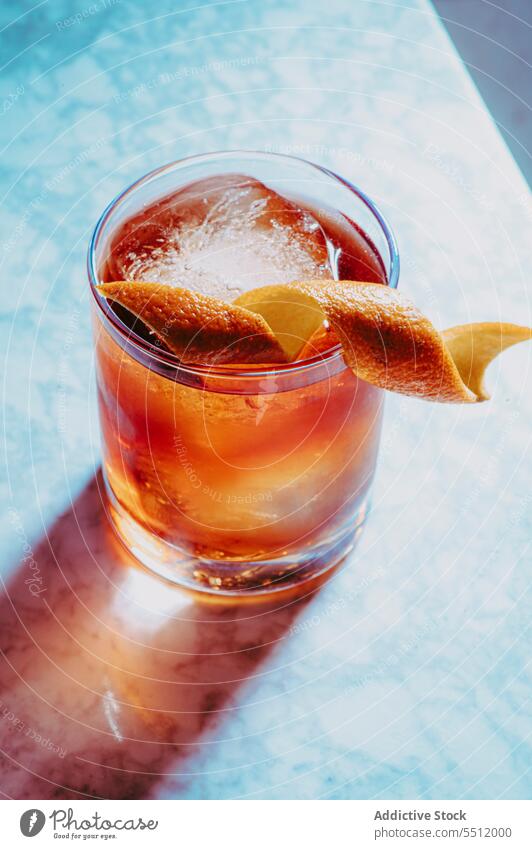 Old fashioned whiskey cocktail with orange peel alcohol old fashioned citrus glass ice cube drink cold liquid aromatic pub bar table marble aperitif appetizing