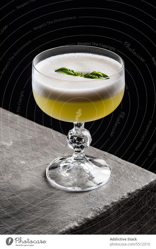 Pisco sour cocktail with mint leaf alcohol pisco sour froth glass liquid aperitif refreshment goblet exotic citrus foam fizz table edge stone ingredient crystal