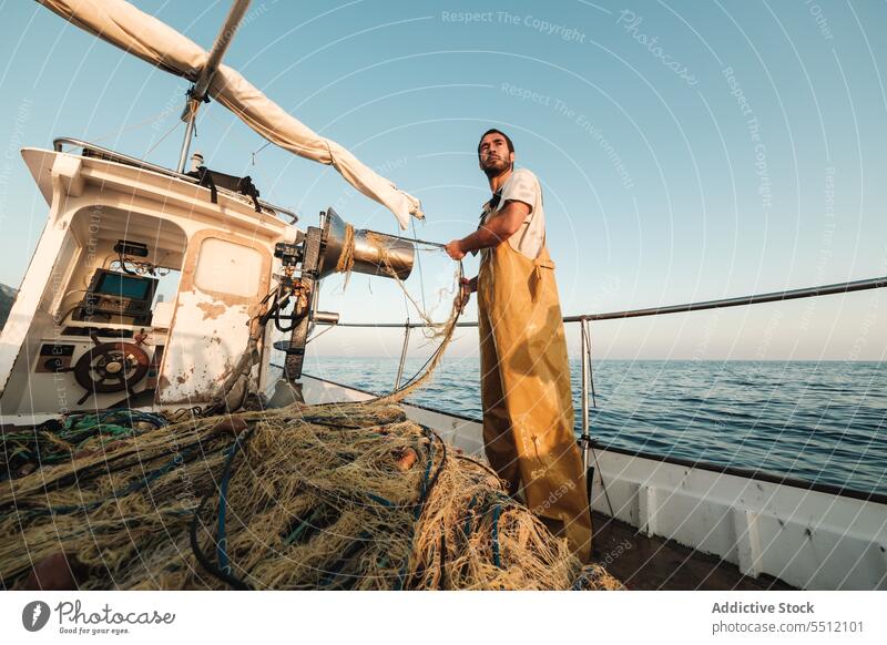 Fisherman fishing in open sea from sail boat fisherman net schooner work uniform male soller balearic islands mallorca seine fish hunt trawler ship yacht