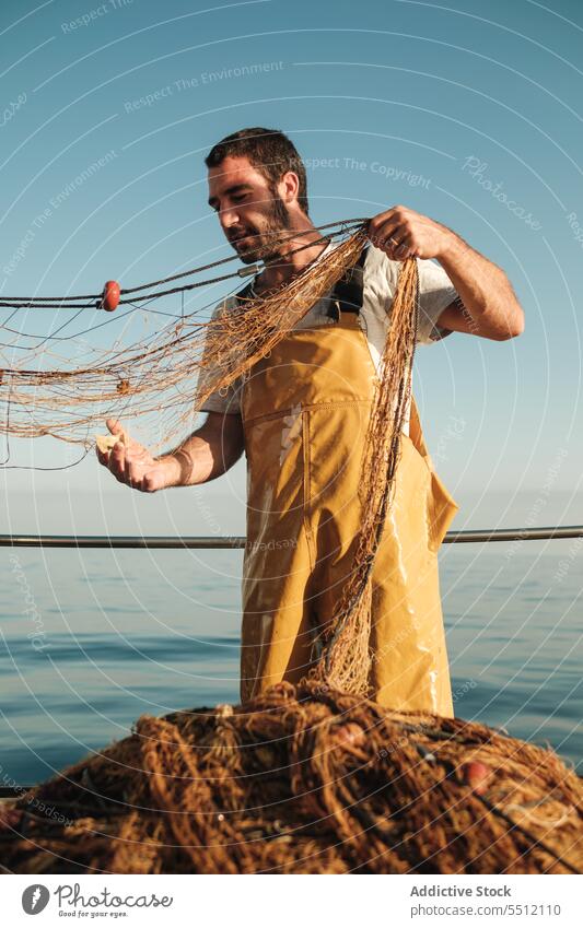 Fisherman fishing in open sea from sail boat - a Royalty Free Stock Photo  from Photocase