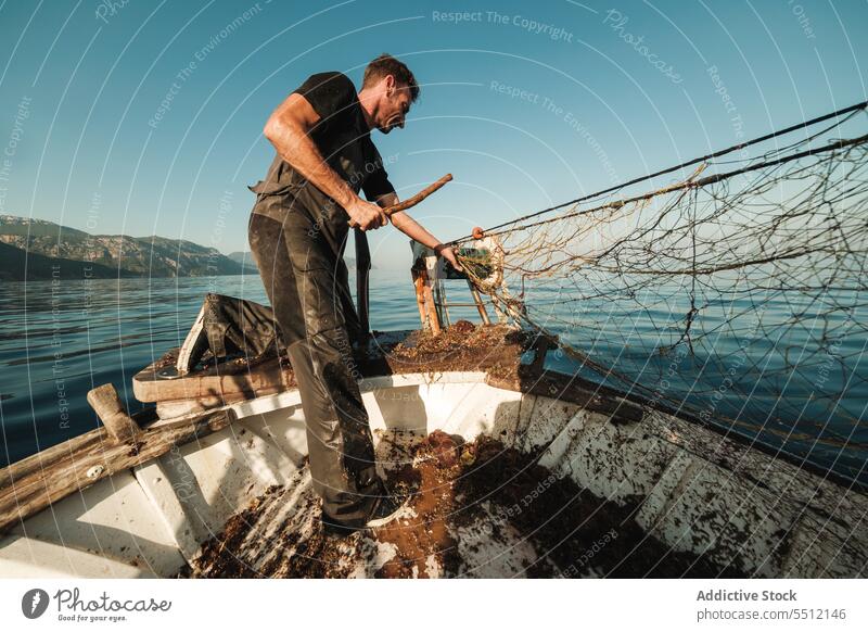 Fisherman fishing in open sea from sail boat fisherman net schooner work uniform male soller balearic islands mallorca seine fish hunt trawler ship yacht