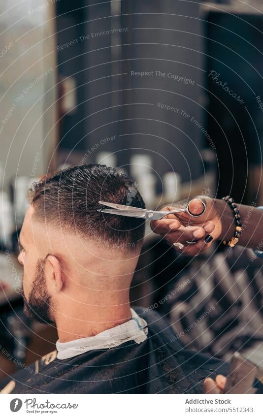 Crop black barber cutting hair of client with scissors men comb haircut barbershop job young male multiracial african american ethnic accurate master workplace