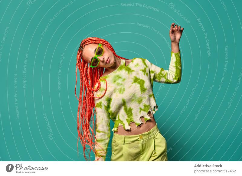 Stylish woman dancing in green outfit and sunglasses confident stylish fashion model motion studio shot unemotional dance cool vivid appearance young female