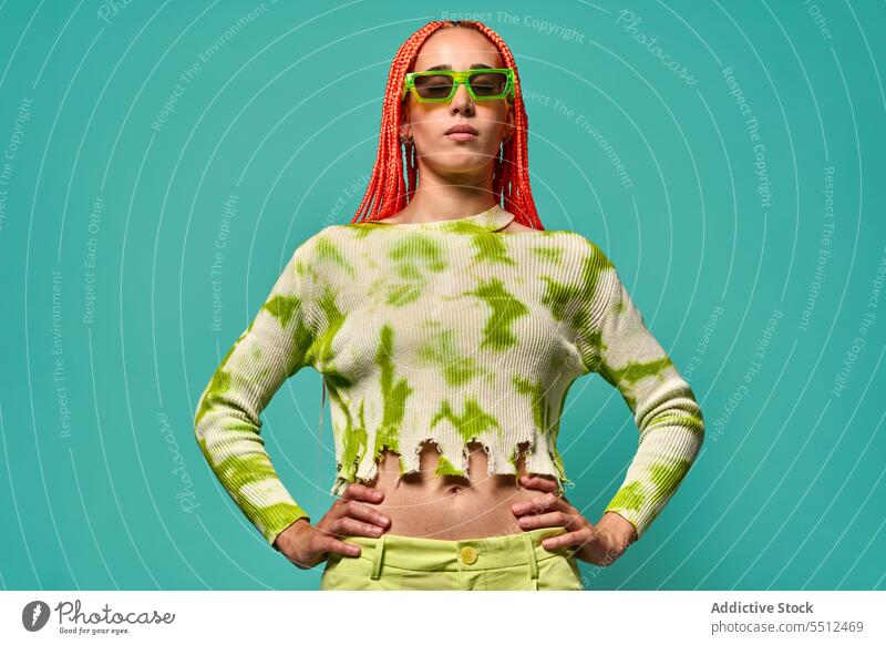 Stylish woman in green outfit and sunglasses confident stylish fashion model studio shot unemotional cool vivid appearance young female afro braids long sleeve