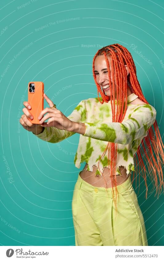 Stylish happy female with Afro braids taking selfie on smartphone woman using cheerful smile take photo stylish studio shot model social media charismatic