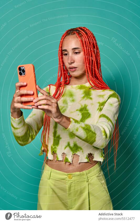 Stylish female with Afro braids taking selfie on smartphone woman using take photo stylish studio shot model social media charismatic self assured confident