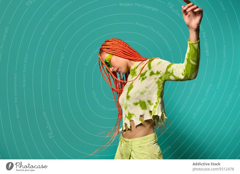 Stylish woman dancing in green outfit and sunglasses confident stylish fashion model motion studio shot unemotional dance cool vivid appearance young female