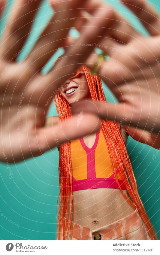 Female hipster hiding face from camera woman shy cover face arms outstretched hide studio shot vivid gorgeous vibrant smile happy cheerful young female