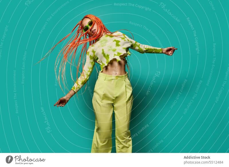 Stylish woman in green outfit and sunglasses confident stylish fashion model studio shot unemotional cool vivid appearance young jump female afro braids