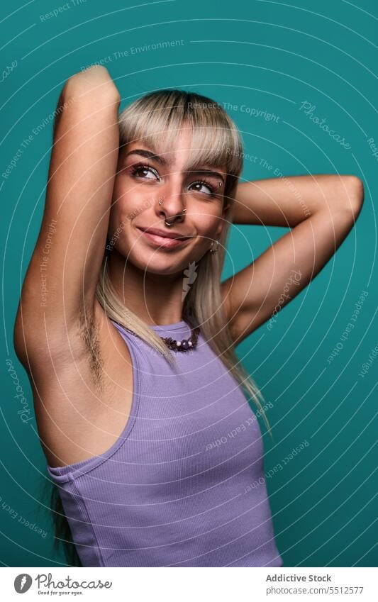 Confident smiling woman with hairy armpit hipster body positive hand behind head arms raised portrait natural accept studio shot confident self confident