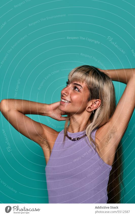 Confident smiling woman with hairy armpit hipster body positive hand behind head arms raised portrait natural accept studio shot confident self confident
