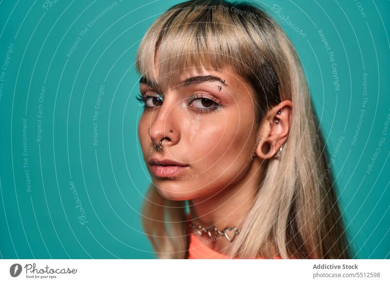 Informal female model with piercing on face woman portrait hipster human face studio shot informal subculture confident cool smile self assured self confident