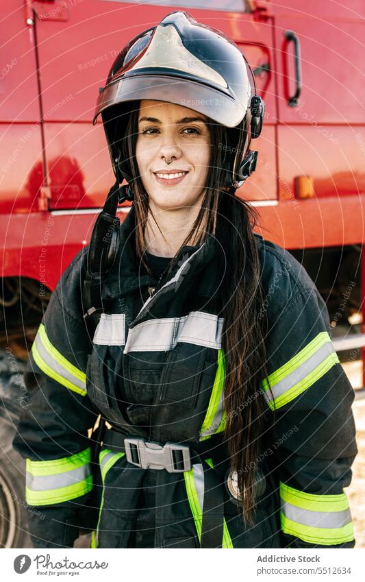 Woman firefighter in protective uniform and helmet woman safety occupation job female service professional emergency vehicle work workwear transport worker
