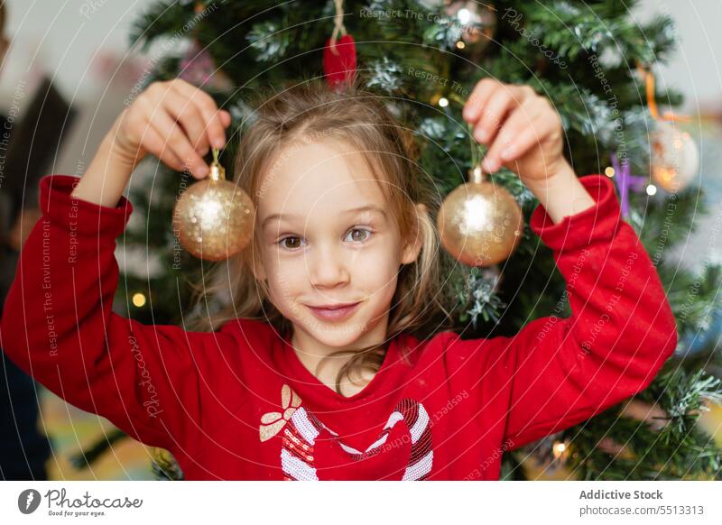 Girl with bauble against Christmas tree Russia winter girl christmas tree decorate holiday home prepare kid child eve festive merry december xmas occasion