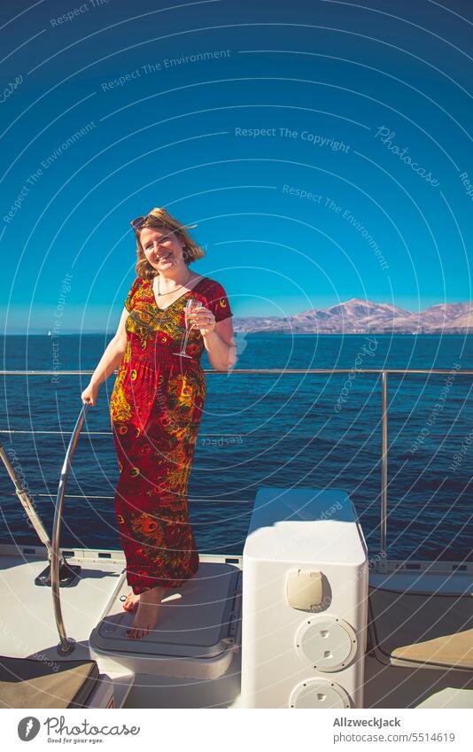 Portrait of a middle aged woman in a red dress with a champagne glass on a boat Summer Summer vacation Summertime Summery Vacation mood Vacation & Travel