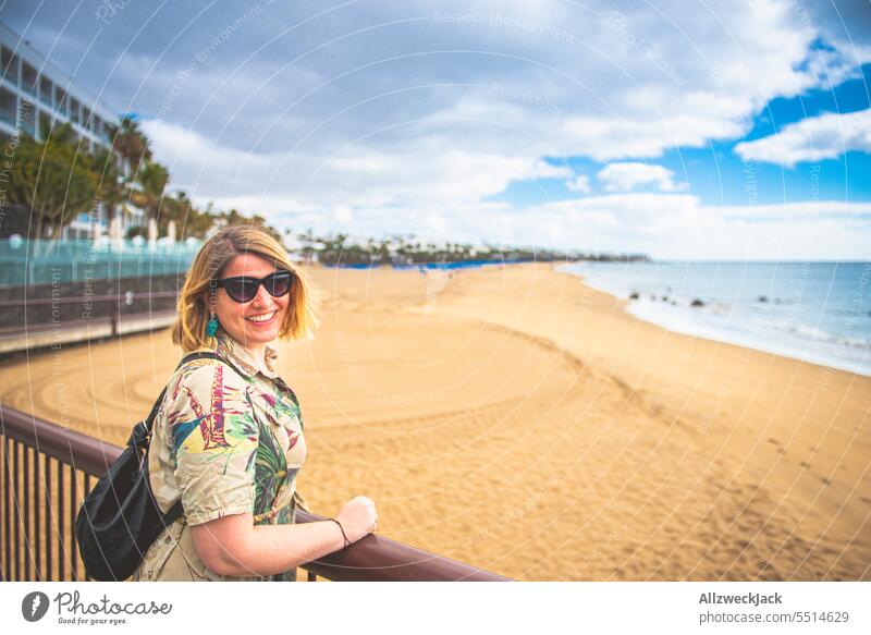 Portrait of a middle-aged woman with sunglasses and dress on a wide beach of Lanzarote portrait short-sleeved vacation Vacation mood Vacation photo