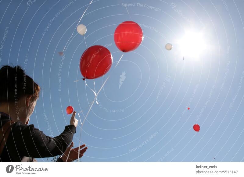 Unrecognizable people let red and white balloons fly into the sky towards the sun persons Red White Sky Blue Balloon Flying Sunbeam Anonymous Light Birthday