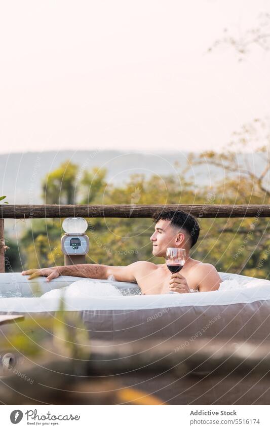 Relaxed man with glass of wine chilling in pool calm alcohol drink relax terrace water inflatable male foam glamping beverage rest refreshment weekend