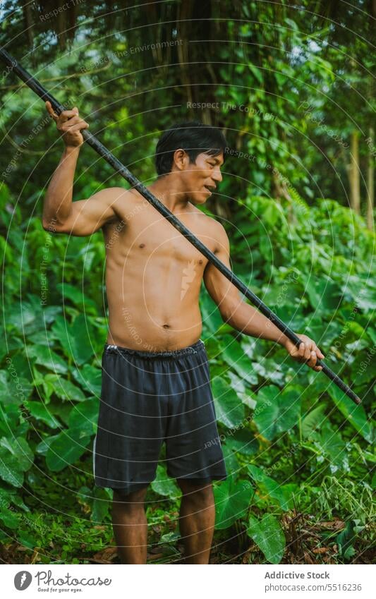 Shirtless tribal man with blowgun in tropics tribe jungle indigenous rainforest native huaorani waorani exotic culture travel environment authentic local hunt