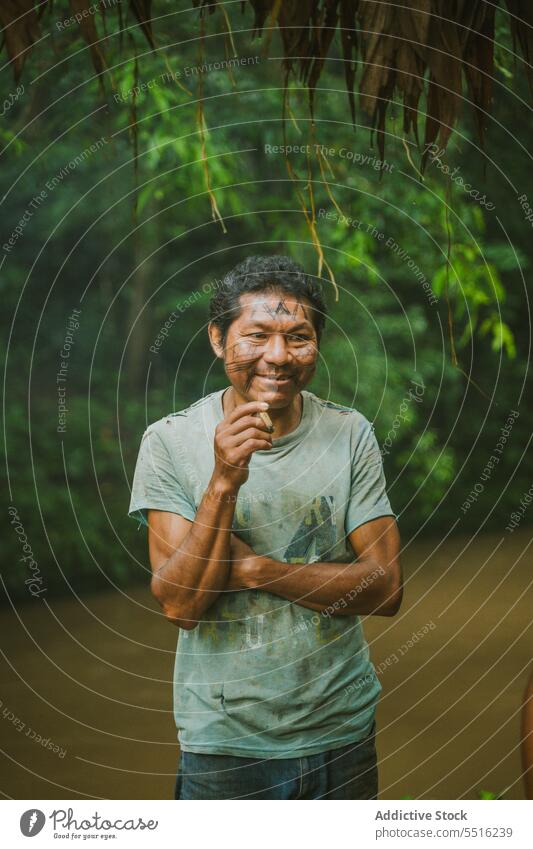 Smiling ethnic man of local countryside smoking smile smoke tropical river relax portrait exotic rainforest fisherman friendly mature shore authentic cigarette