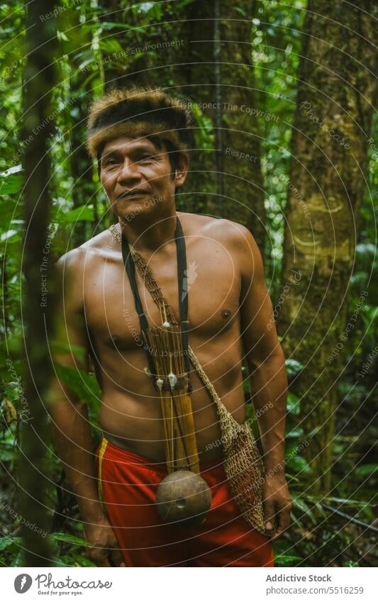 Shirtless man of Amazon tribe with tools on neck jungle nature shirtless tradition local forest environment tree male green naked torso culture native
