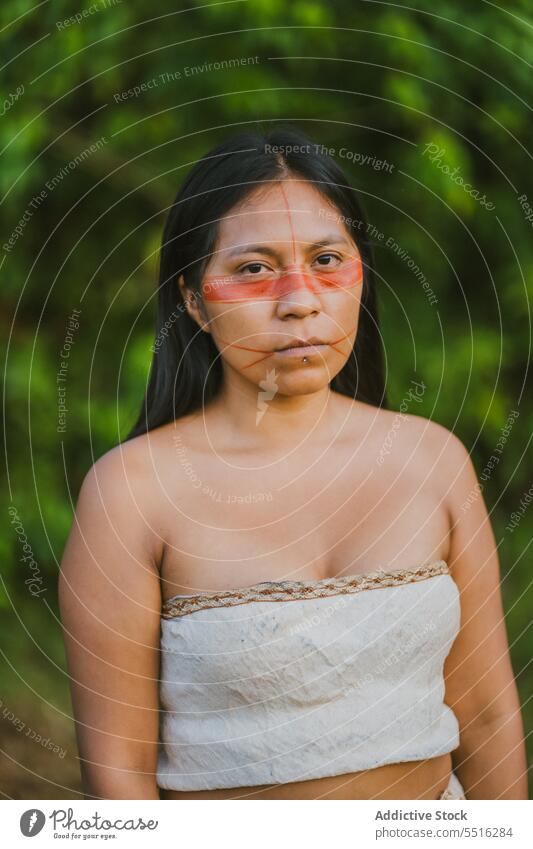 Serious woman with paint on face nature forest serious culture tradition green summer authentic female woods tribal plant environment floral woodland natural