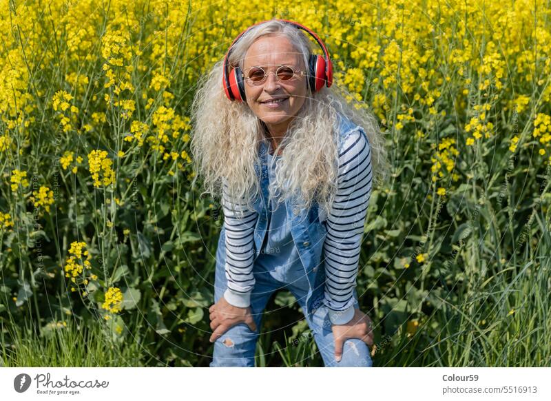 Cheerful senior woman with red headphones mature caucasian smile beautiful music casual female nature old aged cheerful portrait lifestyle looking adult happy