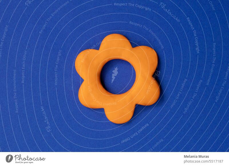 Simple three dimensional sign of flower. Symbol of prosperity, growth concept, growing buissnes. Orange flower icon on blue background, environmental, gardening, horticulture topics.