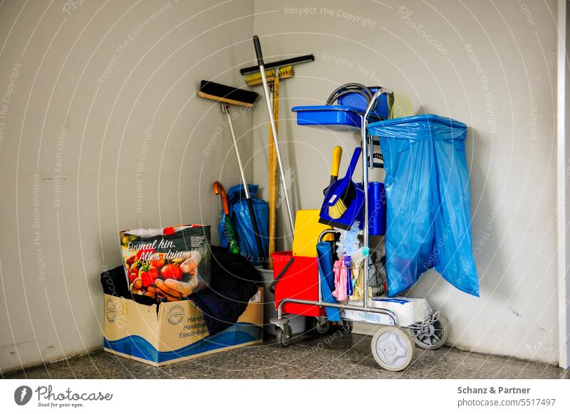 Cleaning cart with cleaning supplies, bases and garbage bag is in the corner against the wall cleaning power do the cleaning Wipe polish skilled workers Cleaner