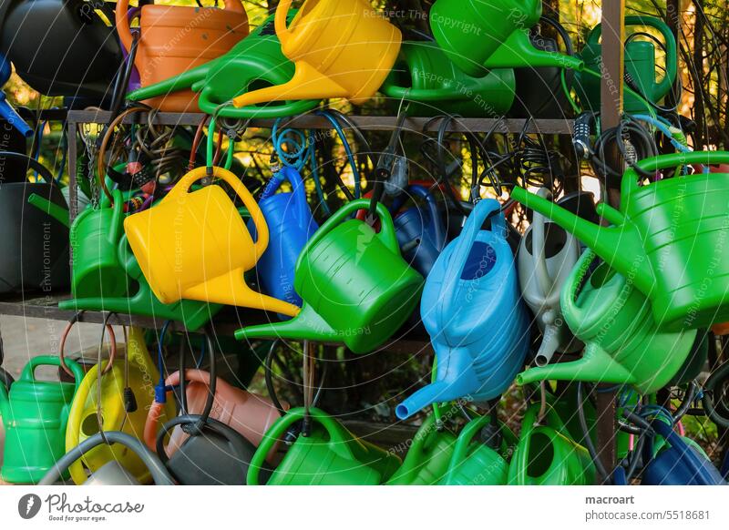 Many colorful watering cans hang on a shelf with locks in the cemetery Jug Cast Closed Associated Lock Green Yellow Blue soak Irrigation lend Exterior shot