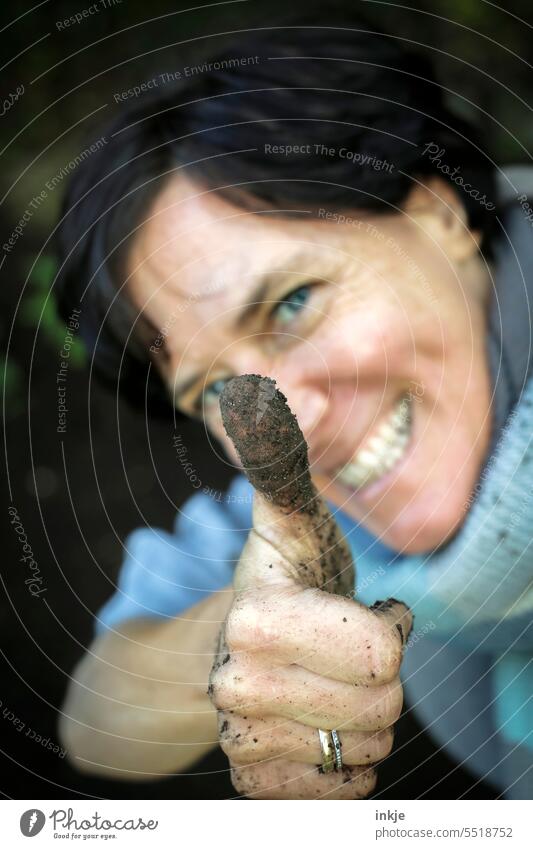 dirty thumb of a laughing woman Colour photo Exterior shot one woman Gardening Laughter Woman 50 - 55 years Black-haired Face kind facial expression Joy Dirty
