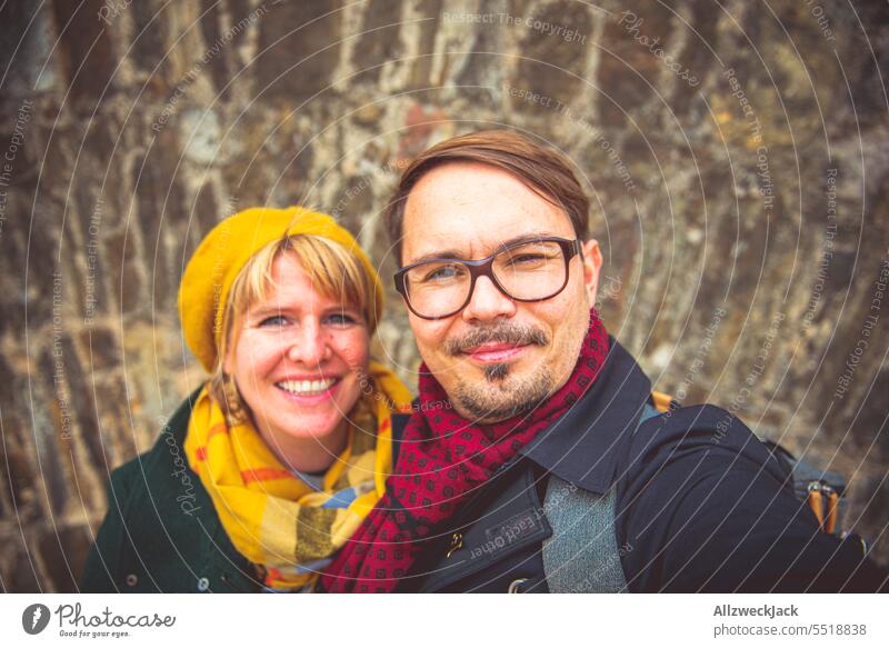 happy couple in autumn clothes makes a selfi in front of a wall Selfie Couple Couples Middle aged couples Autumn Autumnal germany trip home leave Man