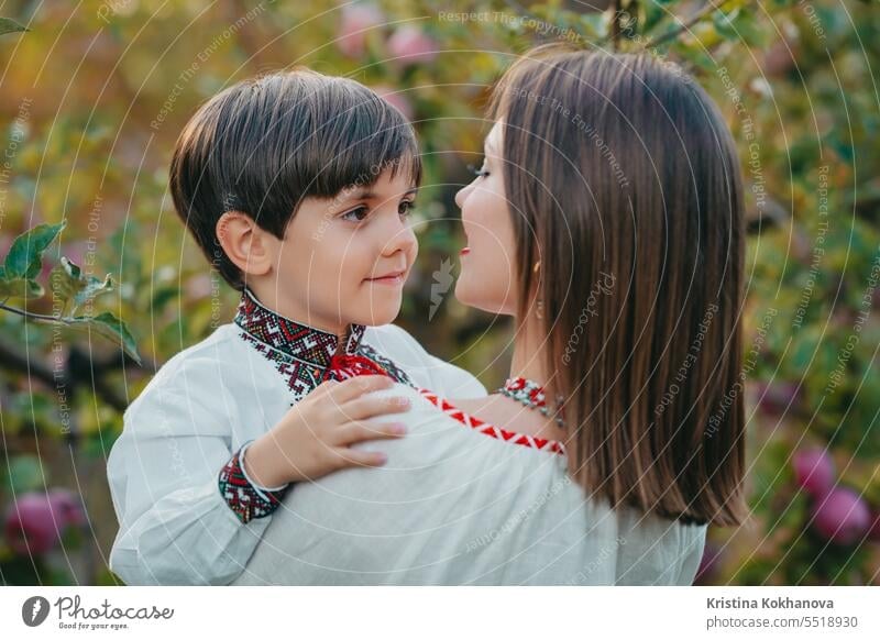 Portrait of family - 4 years old boy embracing mother in apple orchard. Tender. mom son happy hug love parent care happiness hugging motherhood parenthood