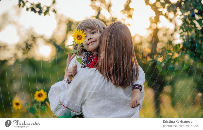Portrait of beautiful family - 4 years old boy with sunflower, mother in garden mom ukrainian son happy hug love parent care happiness hugging motherhood