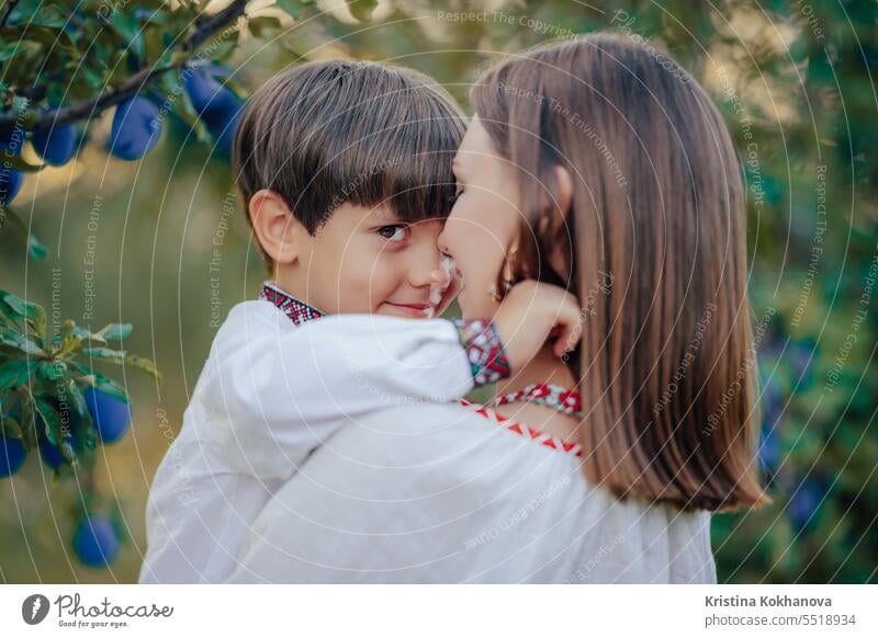 Portrait of sweet family - 4 years old boy and mother in plum orchard mom son happy hug love parent care happiness hugging motherhood parenthood smiling