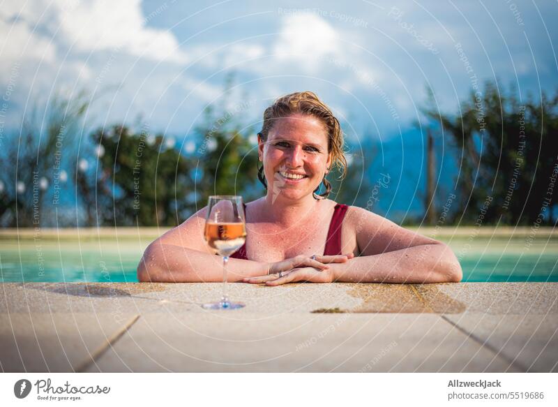 young smiling woman with wet hair leaning on poolside with glass of white wine Young woman Woman pretty Congenial Refreshment Cold drink White wine Vine Glass