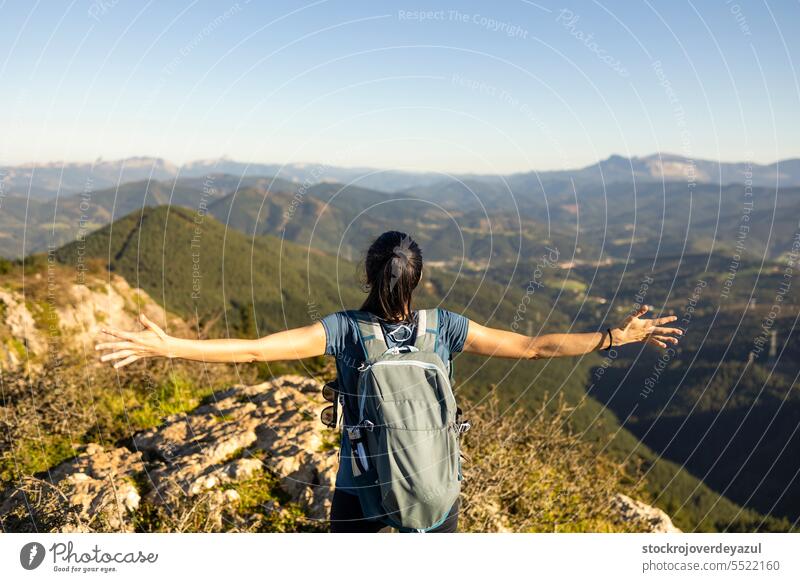 A young woman opens her arms, marveling at the natural mountain scenery in the Basque Country nature female freedom basque country euskadi pagasarri mountains