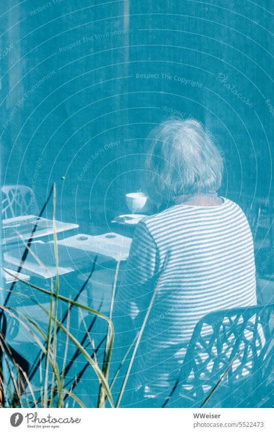 Someone sits in a sidewalk cafe in the sun and drinks coffee while reading Vista Café Sidewalk café Coffee Woman elderly lady Gray-haired Striped Blue Turquoise