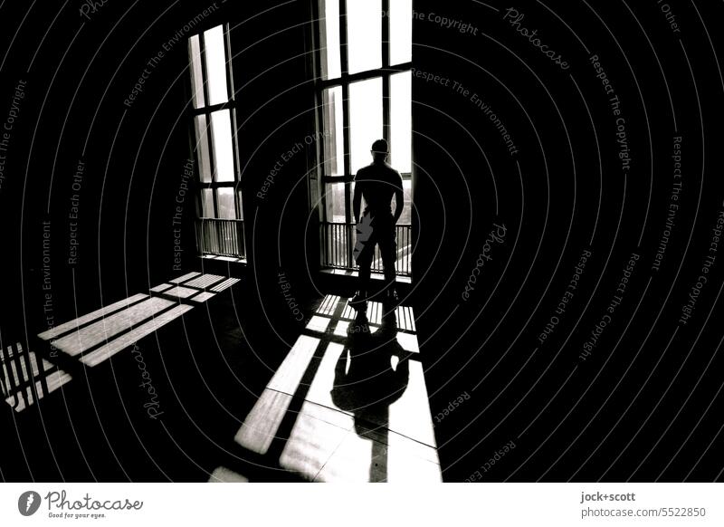 Sunlight shines in as he stands at the large window Staircase (Hallway) Shaft of light Shadow Contrast Structures and shapes Silhouette Architecture Style