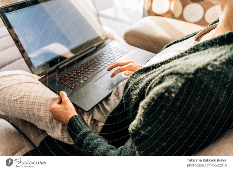 A woman uses a laptop touchpad while sitting at home Online Internet Lifestyles Laptop female Remote work Wifi Computer Wireless Technology people Job Busy