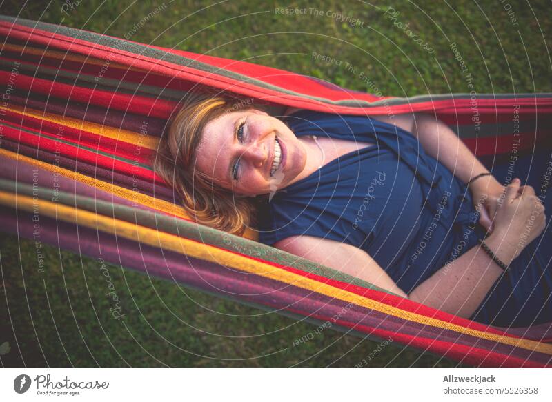Portrait of young blonde woman smiling lying in hammock Woman Young woman Sympathy Congenial pretty pretty woman Attractive attractiveness smilingly Smiling