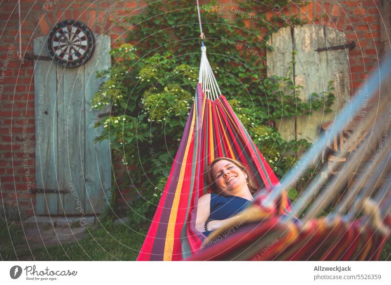 Portrait of young blonde woman smiling lying in hammock Woman Young woman Sympathy Congenial pretty pretty woman Attractive attractiveness smilingly Smiling
