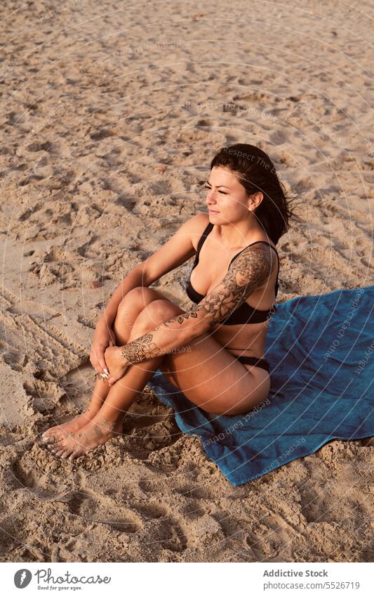Sensual woman in bikini sitting on sandy beach seductive sensual sexy vacation relax contemplate rest summer female holiday swimwear young slim sea recreation