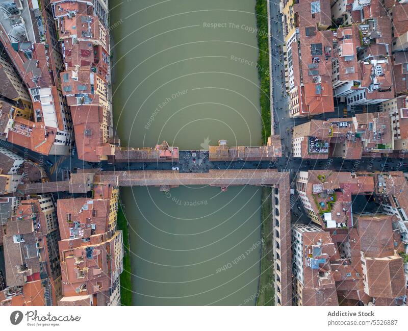 Drone view of bridge over river within city and narrow streets town roof architecture building old exterior cityscape house residential construction structure