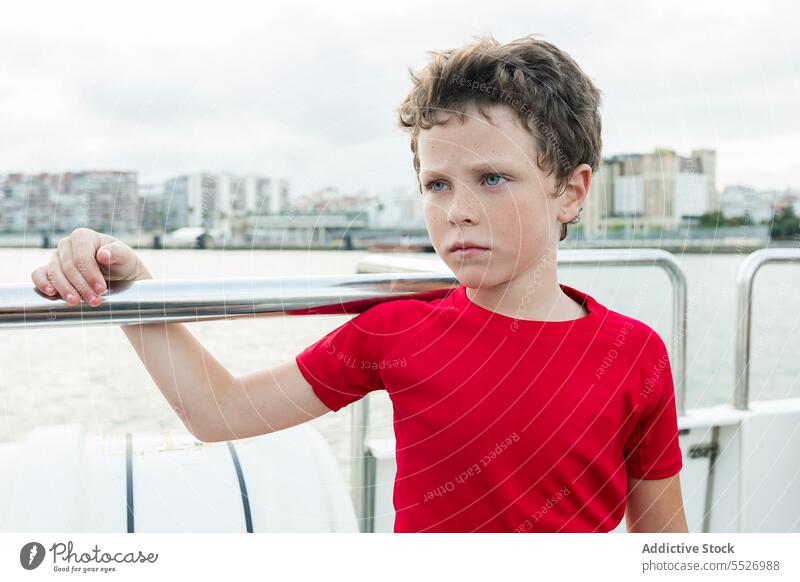 Pensive boy on boat in sea water ship float child yacht enjoy vacation ocean kid sailboat marine childhood thoughtful daytime seascape peaceful fence dreamy