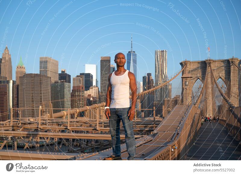 Man standing on suspension Brooklyn bridge infrastructure man thoughtful serious confident african american brooklyn bridge architecture black ethnic metropolis