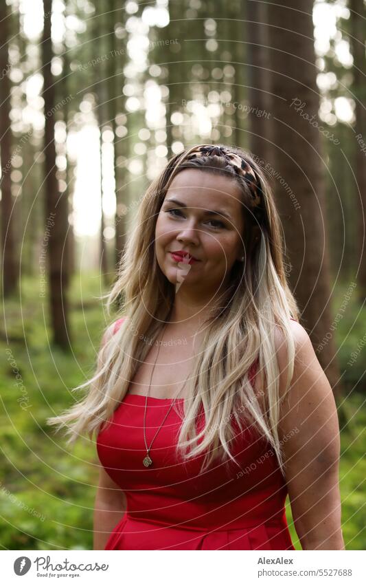 Portrait of beautiful blonde long haired woman standing in light forest looking at camera Woman pretty Blonde Long-haired Blonde hair long hairs red dress Red
